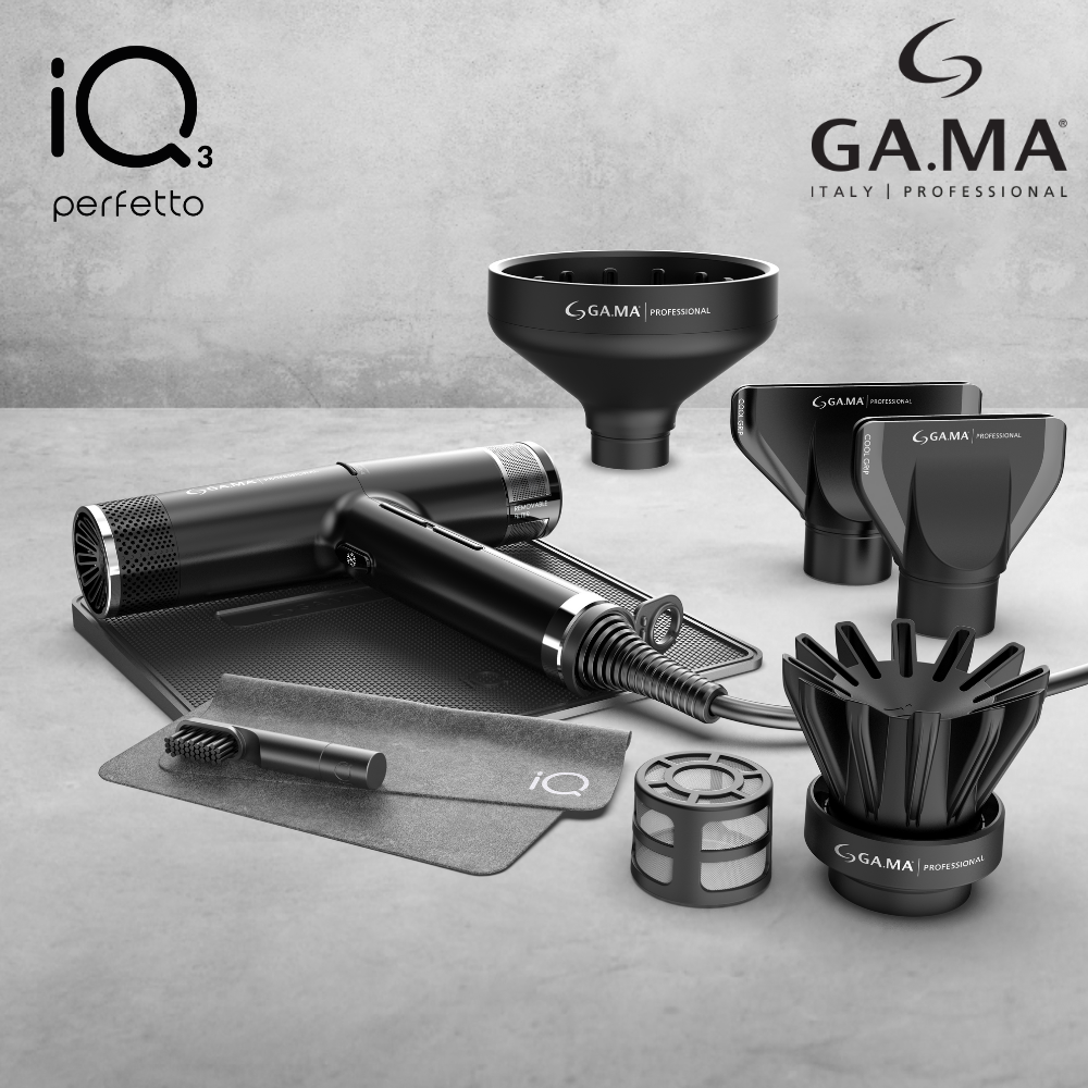 A sleek, modern black Gama Italy Professional IQ3 hairdryer set displayed on a gray surface. The set includes the hairdryer, various attachments such as a diffuser, concentrator nozzles, and a cleaning brush. The hairdryer has a minimalistic, professional design with the "GA.MA Italy Professional" and "IQ3 perfetto" branding visible. The accessories are neatly arranged, highlighting the product's high-quality build and versatility.